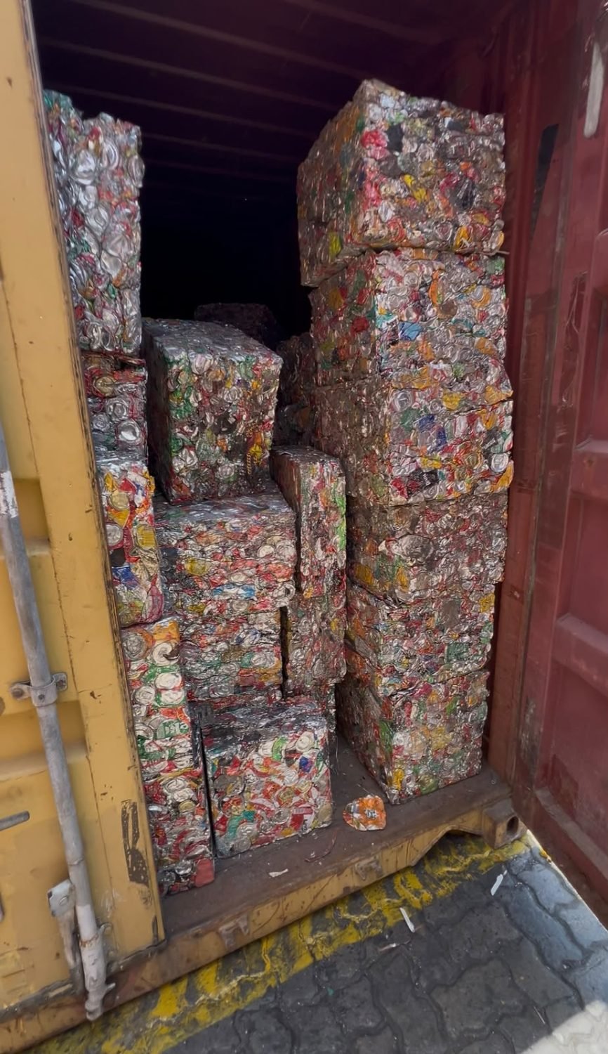 Baled aluminium used beverage cans stacked inside a shipping container